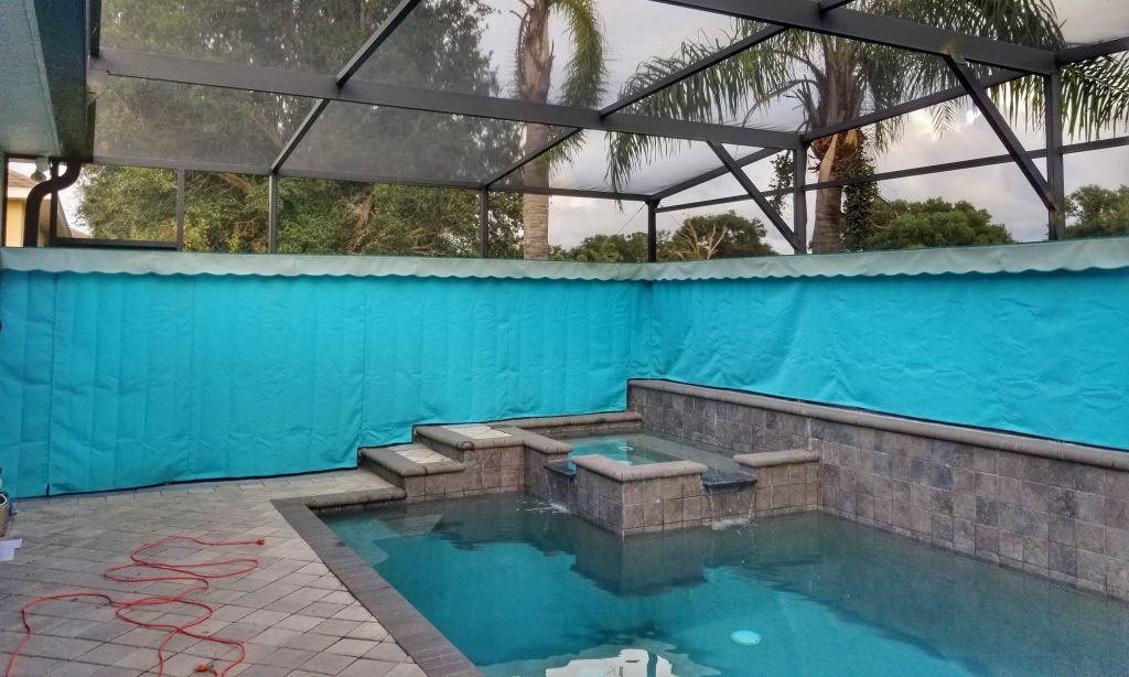 A distributor installing outdoor privacy curtains on a screen enclosure